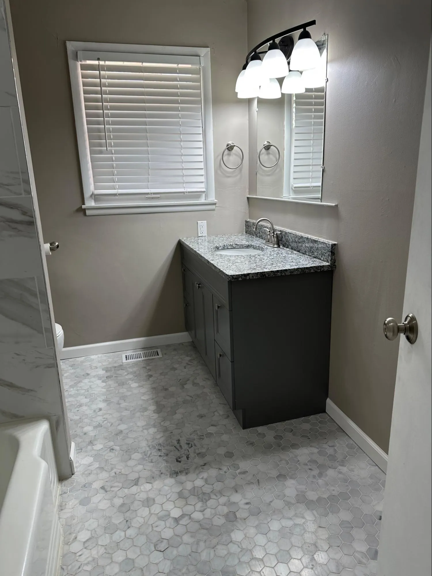 Finished bathroom remodeling with vanity cabinet installation, tile design, and updated fixtures