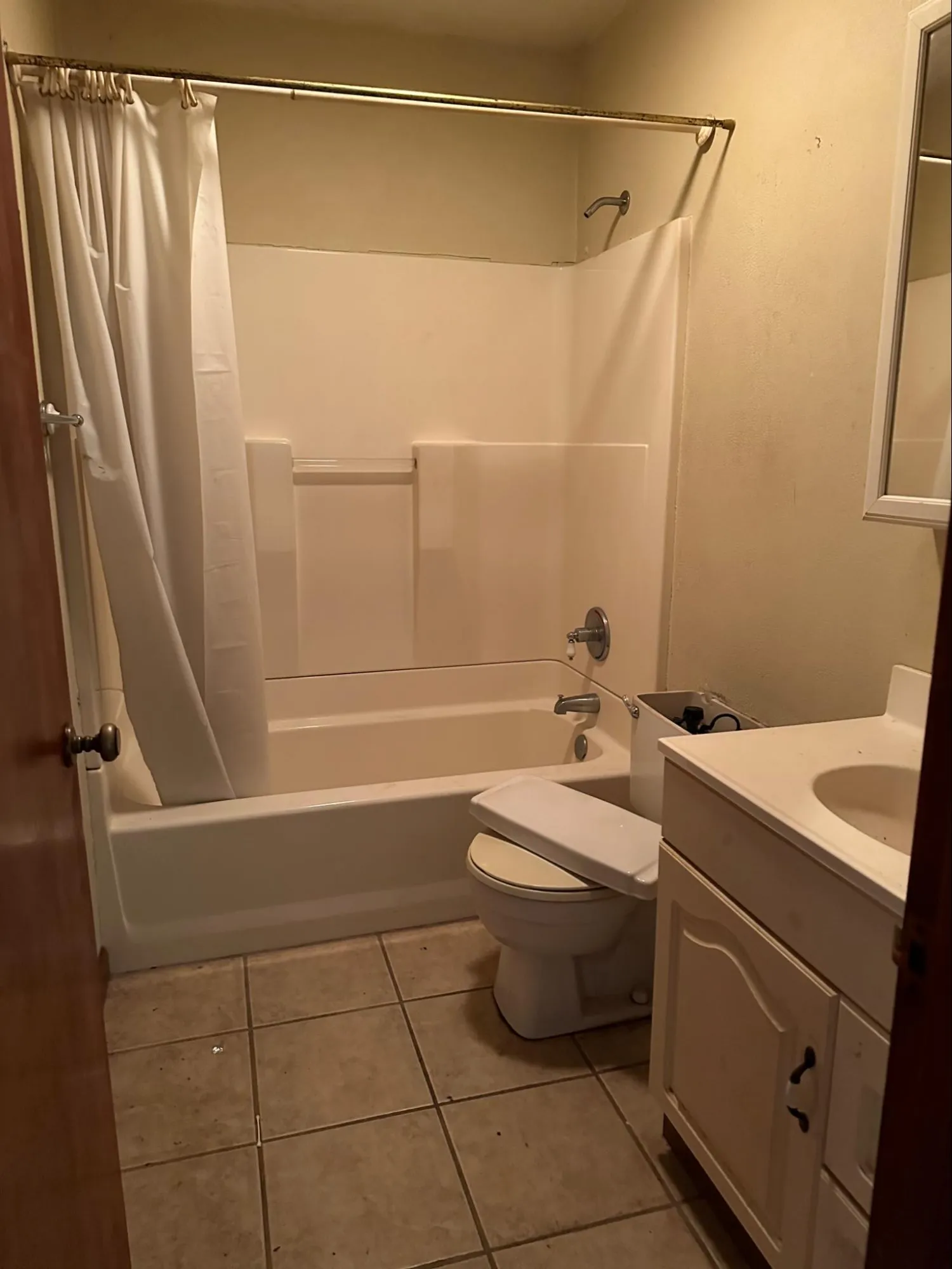 Bathroom before renovation showing aged tile patterns and worn sink fixtures needing upgrades
