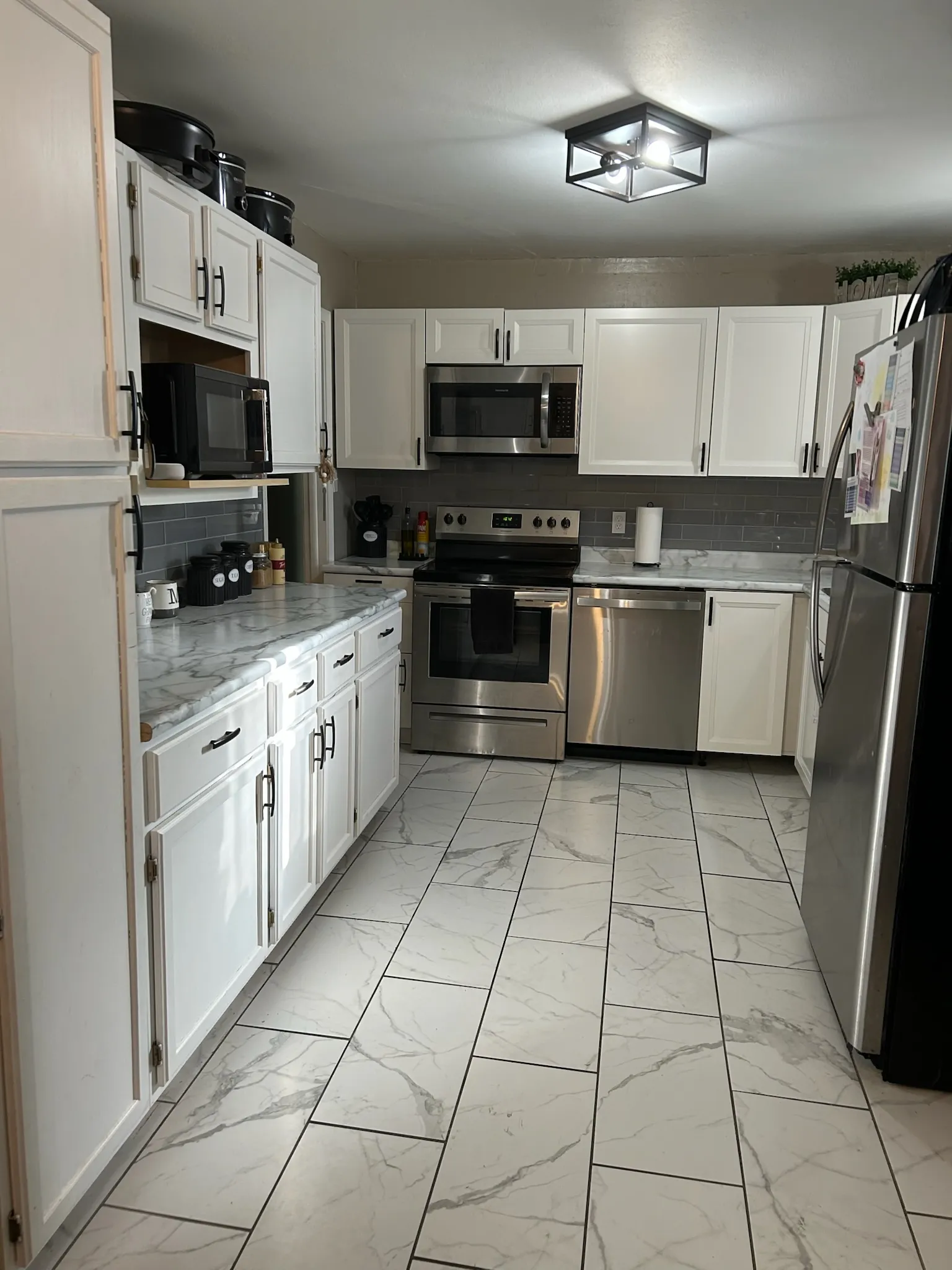 Modern kitchen renovation with white cabinet installation, updated countertops, and professional appliance setup