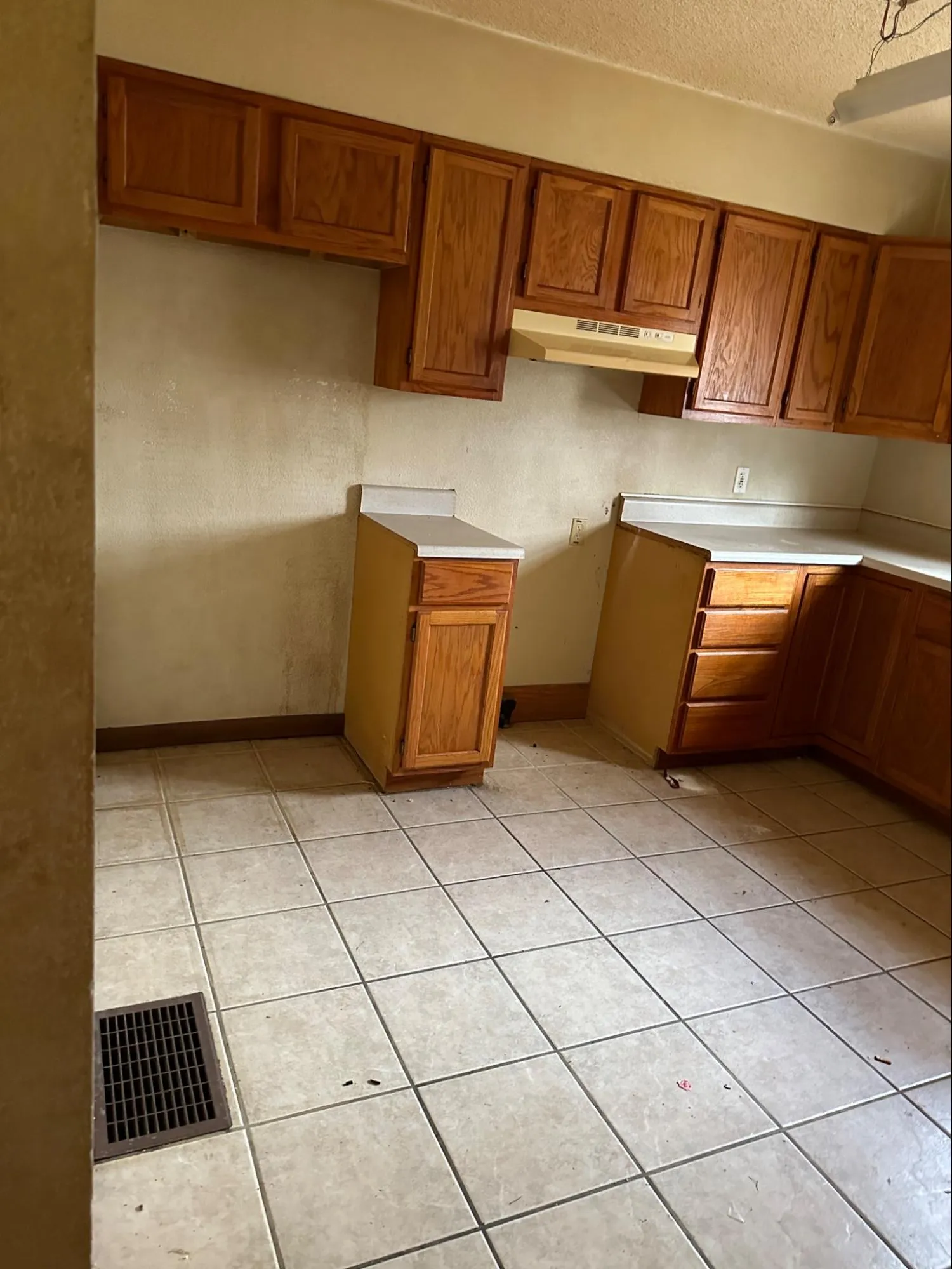 Kitchen requiring professional remodeling with aged cabinet wear and outdated appliance fixtures