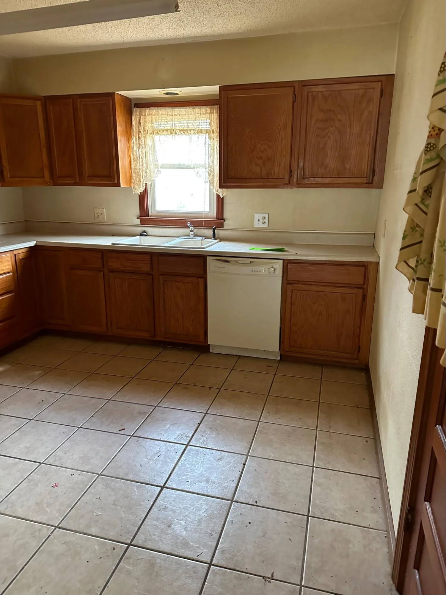 Kitchen before remodeling with aging fixtures, worn cabinet work, and outdated design